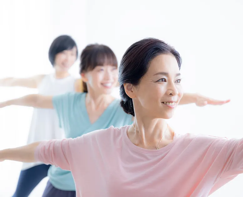 骨盤を両手でおさえる女性