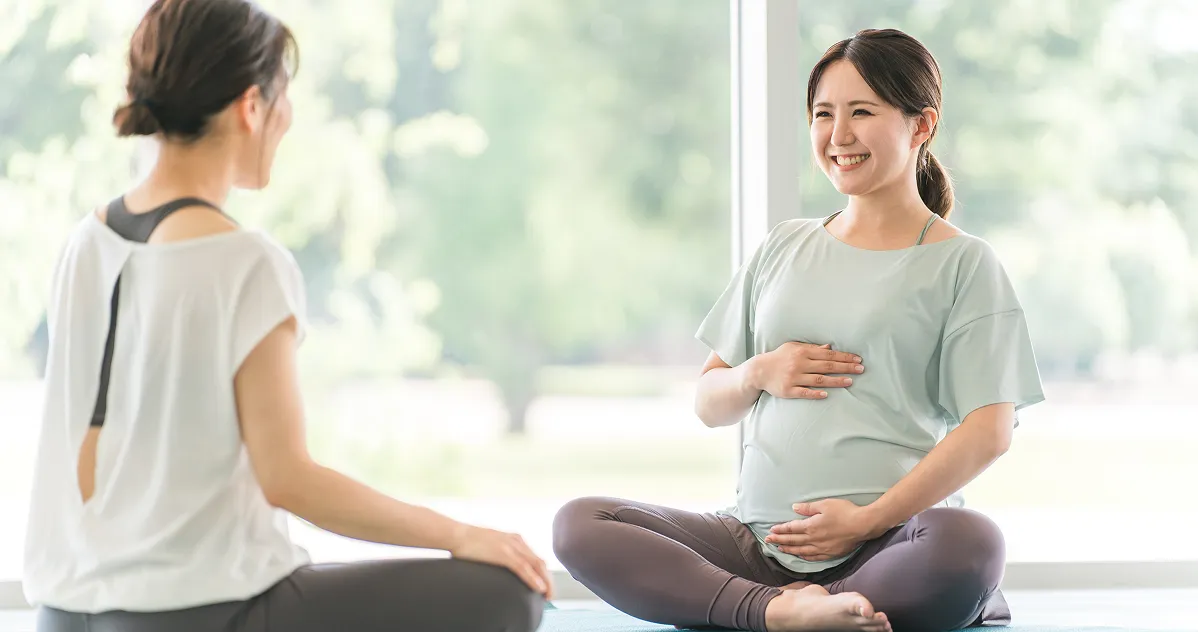 トレーナーとストレッチする女性