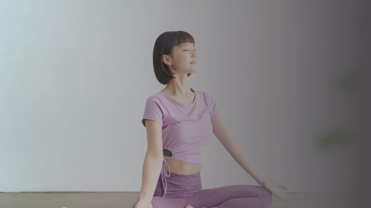 目を閉じて背中を伸ばす女性